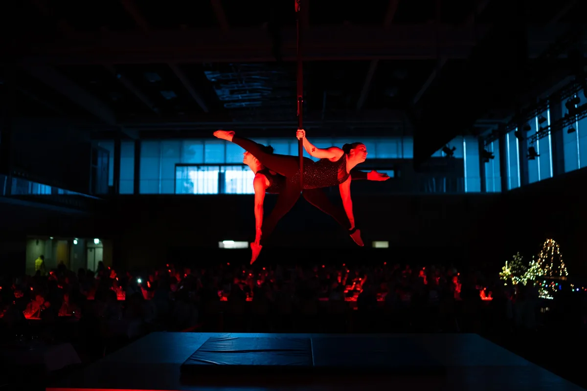 Reportage événementiel ASSA Production : acrobates en performance aérienne sous un éclairage rouge lors d'un gala